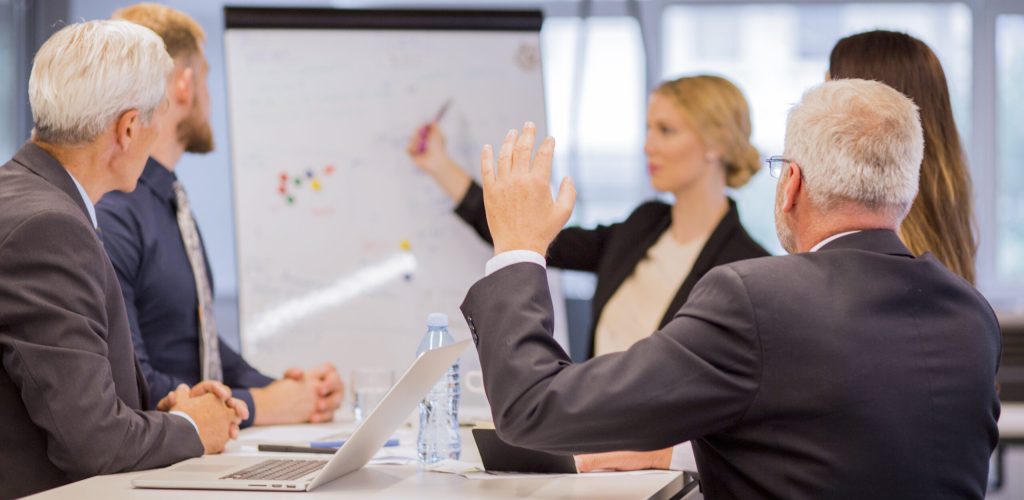 rear-view-senior-businessman-asking-questions-presentation